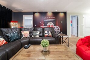 Experience movie nights like never before in this cinema-themed room with plush seating and a popcorn machine!