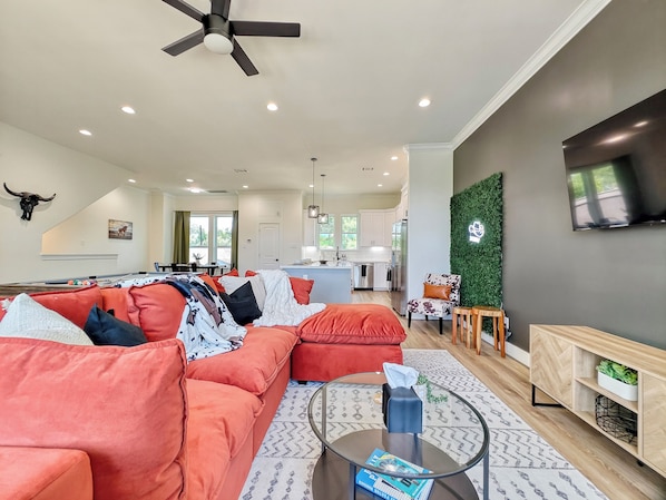 Living room space with huge and plushy couch, and large TV