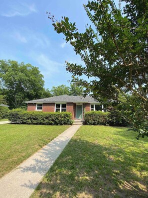 Welcome to this charming single-story brick home, nestled amidst a sprawling green yard, where beautiful trees envelop the property, offering a picturesque retreat. 