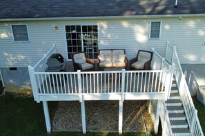 Back deck with gas grill and outdoor seating w/coffee table.