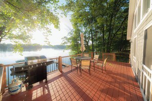 Large deck with dining table overlooking lake