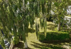 Jardin devant maison avec tables forestières et fauteuils relax