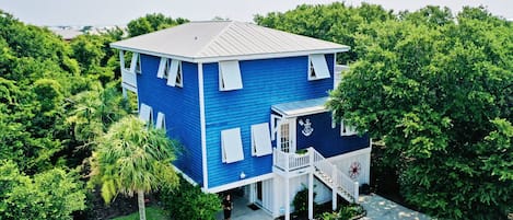 Knotty Dog is a single-family home set among the trees in the upscale Kure Beach neighborhood of SeaWatch