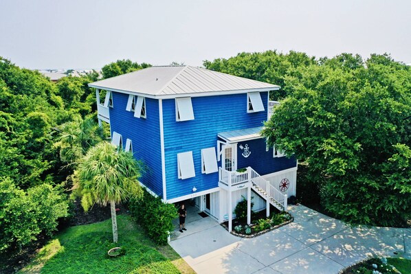 Knotty Dog is a single-family home set among the trees in the upscale Kure Beach neighborhood of SeaWatch