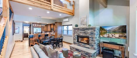 Valuted ceiling living room provides comfortable seating for gathering around the gas fireplace