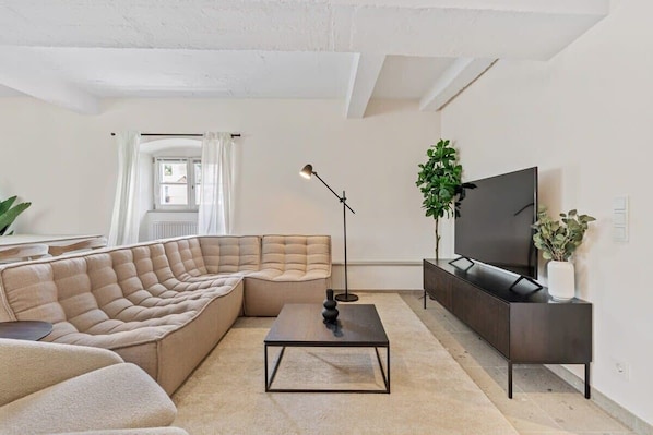 Relax in style in our spacious living room, complete with a large TV. Direct bookings: www.arcaproperties.lu