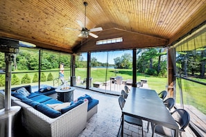Waterfront Cottage Screened in veranda, with propane table fire pit, and heaters, fans, outdoor couch and table. 