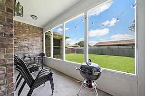 Backyard with sitting area and grill.