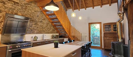 Fully-equipped kitchen showcasing historical beams and natural sunlight.