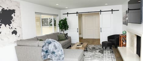 Upstairs living room has barn doors for extra privacy if murphy bed is used