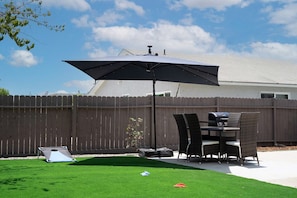 Backyard with large umbrella, grill and patio table