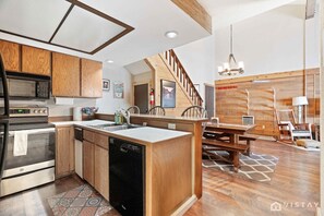 The fully equipped kitchen boasts stainless steel appliances and ample counter space, making meal preparation a breeze.