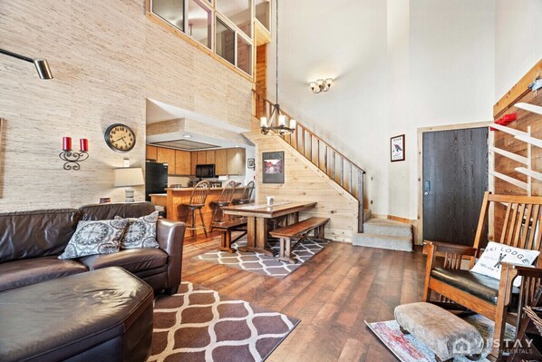 Unwind in the spacious living room, featuring a huge curved sofa, a TV, a wood-burning fireplace, and a rocking chair, creating the perfect atmosphere for relaxation and entertainment.