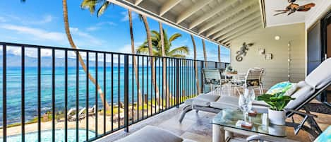 Lanai features lounge chairs, a dining table and ceiling fans