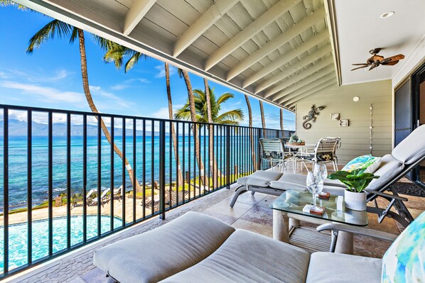 Lanai features lounge chairs, a dining table and ceiling fans