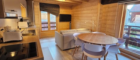 An efficient kitchen and living space with exposed beams and woodwork.