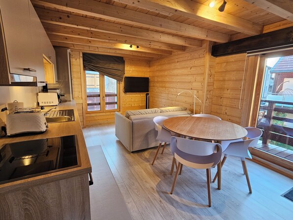 An efficient kitchen and living space with exposed beams and woodwork.