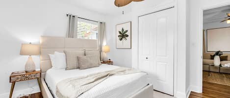 3rd Bedroom: This bedroom features a queen bed with a high upholstered headboard, two mid-century artistic end tables, and two uniquely patterned lamps. There is a 42" Fire TV to stream your favorite shows and movies, and a USB charging station on each end