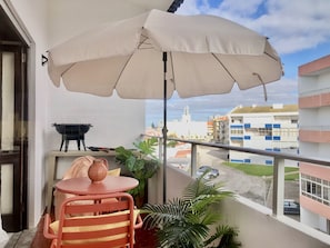 Varanda com lounge, chapéu e pequeno BBQ
Vista de mar, á distância