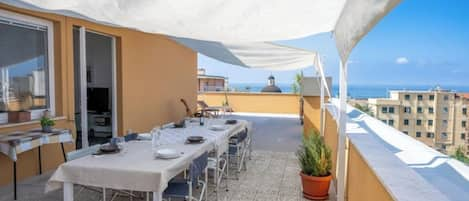 Ampia terrazza vista mare con tavolo per pranzi e cene all'aperto.
