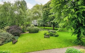 3 acres of groomed lawns and mature trees, with picnic tables and a tennis court