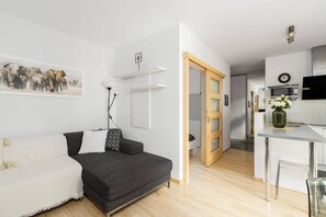 A small living area with a gray sofa, stylish decor, and a compact dining space.

