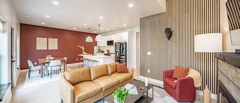 Living room with a leather couch and a cozy fireplace.