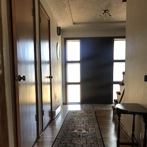 Looking at front door. Hallway goes to bedrooms, bathroom and/or kitchen.