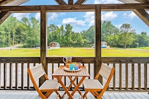 The spacious living room opens out onto the deck overlooking the outdoor game area which includes horseshoes and cornhole.