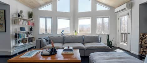 Open floor plan living room with cathedral ceiling facing mountain views.