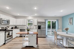 {KITCHEN} with all its sleek stainless steel appliances. 