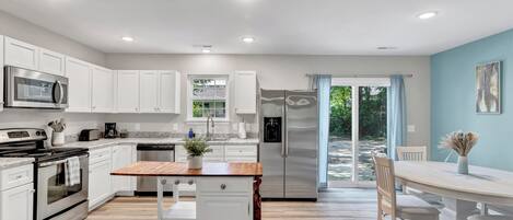 {KITCHEN} with all its sleek stainless steel appliances. 