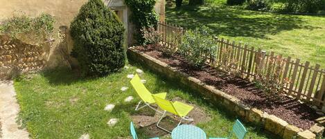 Jardin au Sud avec transats, table, chaises et barbecue.