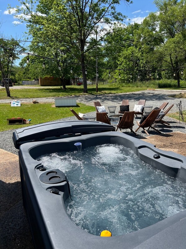 Enjoy the Back yard complete with Hot tub nestled under twinkle lights overlooking the fire pit stocked with wood.  Corn hole and bear pong available to play in the grass.