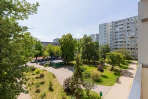 A scenic view of the neighborhood with green trees and residential buildings.

