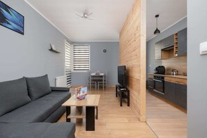 A cozy living room with a gray sofa, coffee table, and warm wooden accents creating a modern ambiance.

