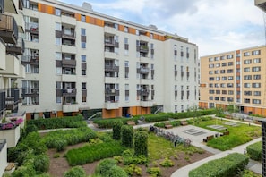 An outdoor view of a well-maintained courtyard surrounded by modern residential buildings.

