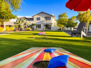 The home includes a putting green, lawn game greenery, 2 firepits, patio cooking areas, and a pool and a spa.