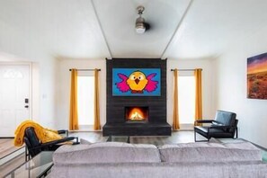 Mounted TV and wood burning fireplace accentuates the luxe living area