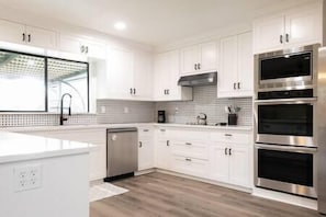 Luxury kitchen with SS appliances, plenty of storage spaces and gorgeous tile backsplash