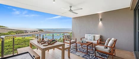The large outdoor entertaining deck offers enclosed privacy as well as a sitting area, a dining table and sparkling water views