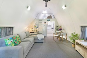  Guests can relax in the downstairs living area, which includes a sofa and a TV 
