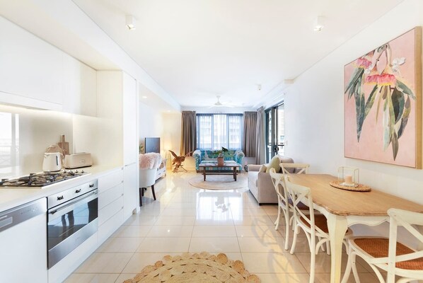 A four-person dining table makes it easy for guests to dine at home, or find countless eateries close by.