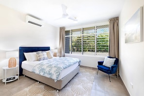The spacious master bedroom features a queen-size bed, a ceiling fan and air-conditioning. 
