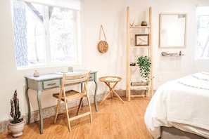 Welcome to the serene master suite of the Wildland Retreat Space, featuring a writing desk with forest views & a private ensuite full bathroom.