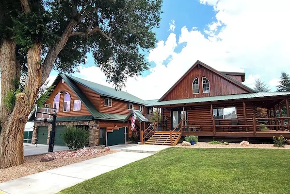 Three car garage with living area above and a cabin adjoined by covered stairs.
