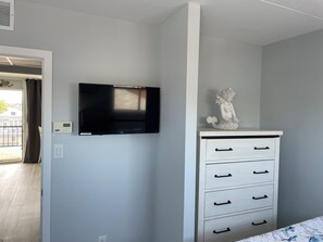 Bedroom has room for clothes and smart tv. 