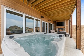 private hot tub on back patio along with tv and fireplace 