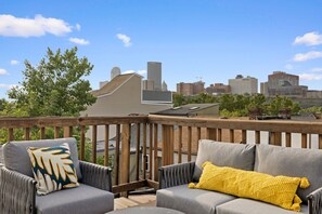 Patio Balcony area with comfy couches and surrounded by trees and skyline