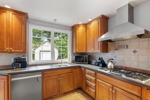 This fully equipped kitchen, which includes a fridge, two built-in wall ovens, a dishwasher, and a gas stove, will thrill food connoisseurs.